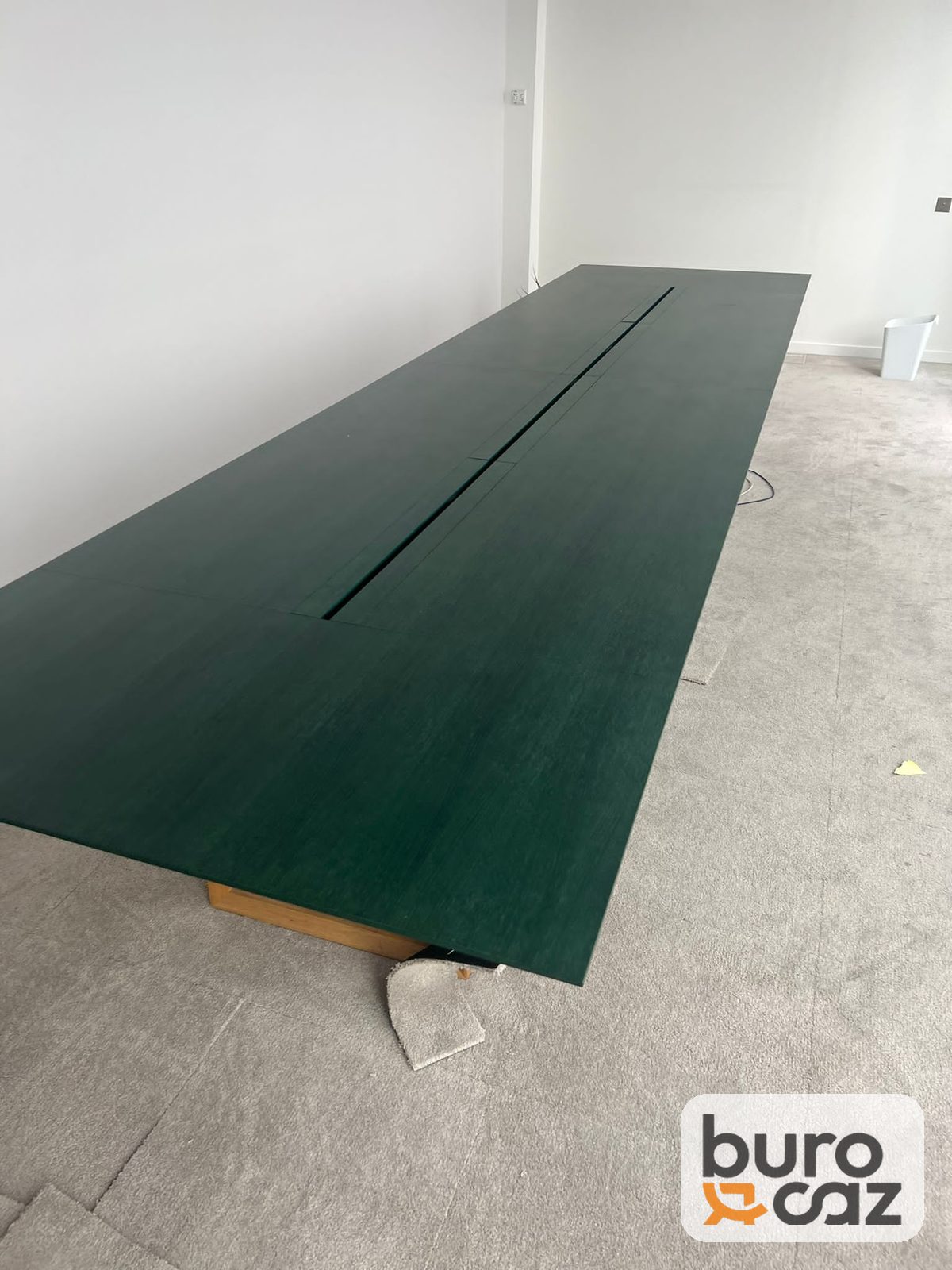 Grande table de réunion vert foncé goulotte centrale piètement bois